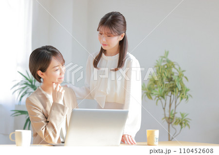 PC操作で困っている同僚に助言するビジネスウーマン1 110452608