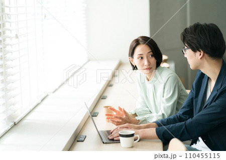 カフェで打ち合わせをする男女 110455115