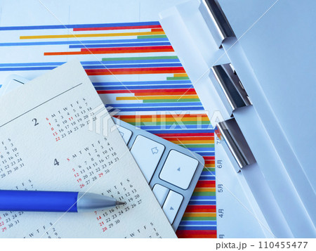 テーブルに置かれたグラフ、カレンダー、書類、キーボード テーブルに置かれたグラフ、カレンダー、書類、キーボード 110455477