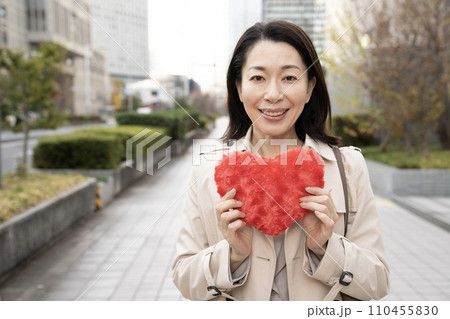 冬の西新宿で赤いハートを持つ女性 110455830