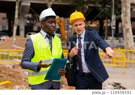Foreman and engineer having conversation about road paving works 110456591