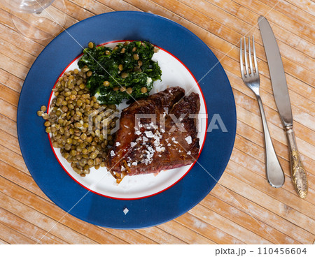 Baked beef loin with green lentils and spinach 110456604