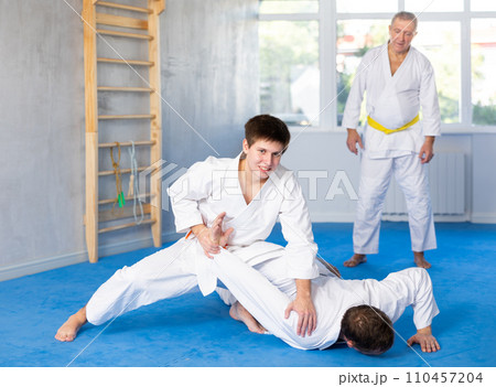 Adult and young men training judo fight Adult and young men training judo fight 110457204