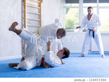 Aged man working on jiu-jitsu techniques in training fight with young rival 110457260
