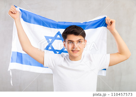 Smiling young guy holding Israel flag 110457573