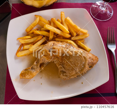 Stewed chicken leg quarter served with crispy fries 110457616
