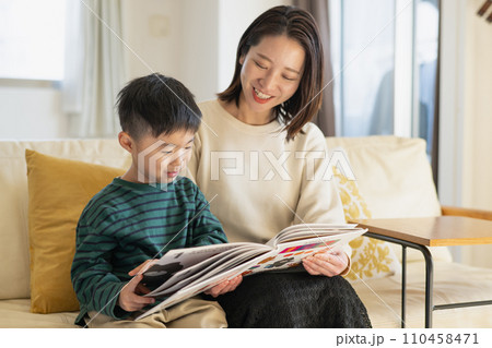 一緒に絵本を見る若い母親と男の子 110458471