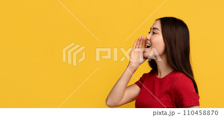 Young asian woman screaming towards copy space, yellow background 110458870