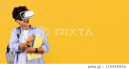 Delighted student with VR headset and books on yellow, copy space Delighted student with VR headset and books on yellow, copy space 110458916