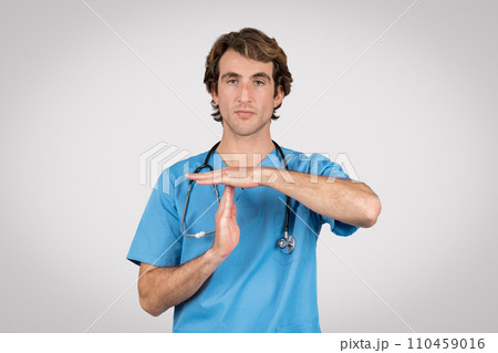 Focused nurse in blue scrubs gesturing timeout signal Focused nurse in blue scrubs gesturing timeout signal 110459016