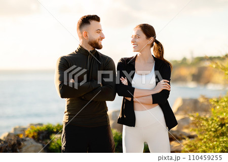 Smiling couple in workout gear enjoying the seaside Smiling couple in workout gear enjoying the seaside 110459255