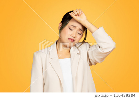 Unhappy despaired young chinese lady in suit pressed hand to head, suffering from migraine Unhappy despaired young chinese lady in suit pressed hand to head, suffering from migraine 110459284