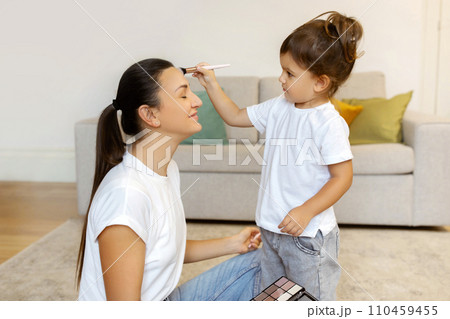 Cute Little Girl Applying Makeup To Mom While They Playing At Home 110459455