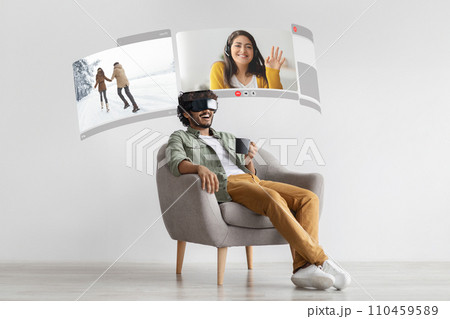 Young arabic man indulges in VR-enhanced video conversations from home, talking with his loving wife via digital screen Young arabic man indulges in VR-enhanced video conversations from home, talking with his loving wife via digital screen 110459589