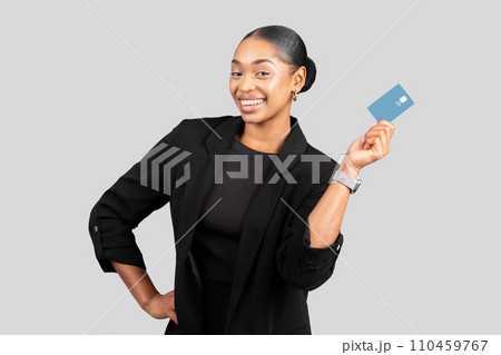 Smiling confident millennial black businesswoman hold credit card 110459767