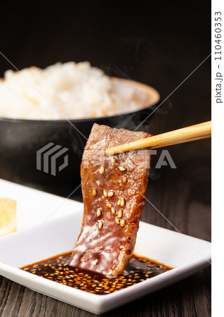 焼肉をタレをつけて食べる 焼肉をタレをつけて食べる 110460353