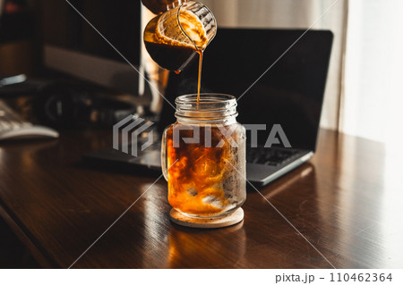 Iced coffee in a mug on the computer table 110462364