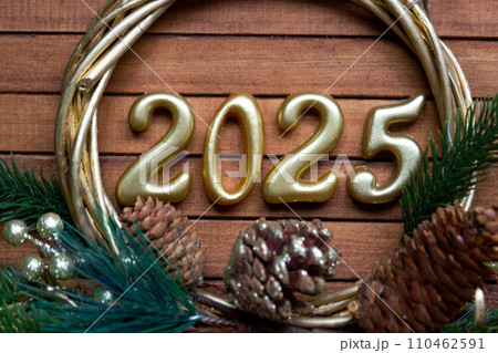Happy New Year golden numbers 2025 on cozy festive brown wooden background with sequins, snow, lights of garlands. Greetings, postcard. Calendar, cover 110462591