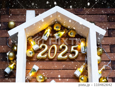 New Year 2025 golden letters under roof house. Calendar, greeting card. Purchase, construction, relocation, mortgage, insurance New Year 2025 golden letters under roof house. Calendar, greeting card. Purchase, construction, relocation, mortgage, insurance 110462642