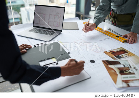 Hands of architects working on building blueprint for client Hands of architects working on building blueprint for client 110463487