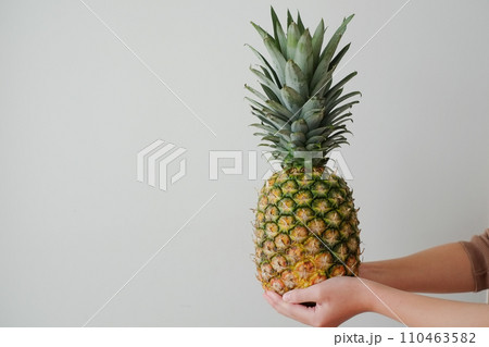 手に持たれたパイナップル 110463582