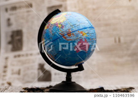 Model globe on a newspaper in the background. 110463596