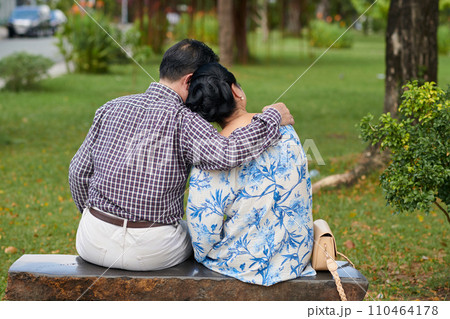 Senior couple in love cuddling in city park, view from behind 110464178