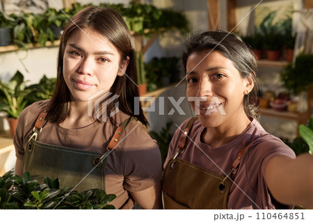 Selfie of two female plant shop workers standing at their workplace and smiling at camera together Selfie of two female plant shop workers standing at their workplace and smiling at camera together 110464851