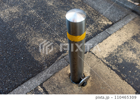 道路に設置された上下式車止めのポール 110465309