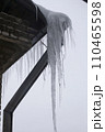 View from the window of huge ice icicles hanging on the roof and drainpipe. Dangerous ice icicles hang on the edge of the roof. 110465598