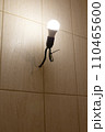 An energy-saving light bulb in a socket with a black wire on a beige wall. The concept of caring for nature. 110465600