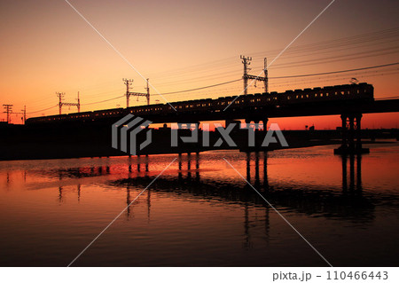 川面に映る夕焼け空と南海電車 110466443