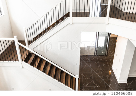 Modern white wooden staircase in new house interior with big windows 110466608