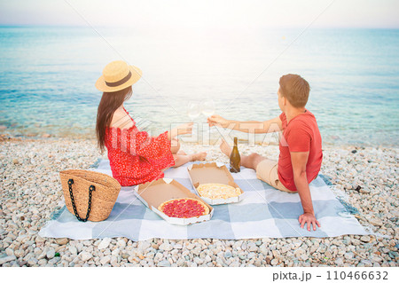 Lovely young couple having a picnic at the beach Lovely young couple having a picnic at the beach 110466632