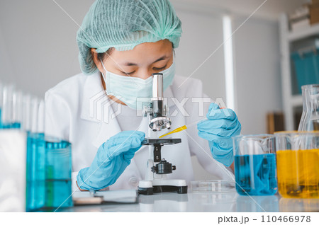 Female researchers are experimenting with pipette dropping a sample into a test tube in an experiment research in laboratory... Female researchers are experimenting with pipette dropping a sample into a test tube in an experiment research in laboratory... 110466978