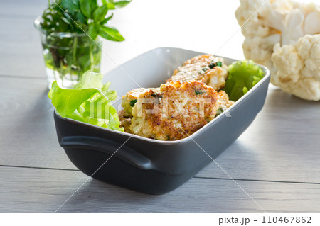 cooked vegetarian fried cauliflower cutlets in a ceramic form . 110467862