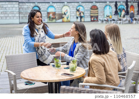 Joyful Reunion at an Outdoor Cafe Joyful Reunion at an Outdoor Cafe 110468557