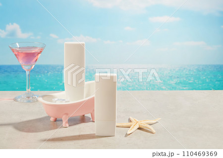 Front view of unlabeled white bottle arranged with pink bathtub, a starfish and cocktail glass with pink beverage. Skin care cosmetic product mockup with empty label 110469369