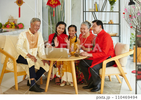 Cheerful three generation family having video call with friends from another country when celebrating Chinese New Year 110469494