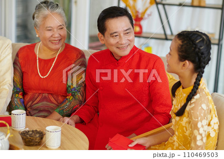 Vietnamese family gathered together to have tea with treats and celebrate Lunar New Year 110469503