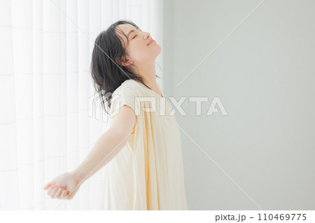 朝の日差しを浴びる若い女性 110469775