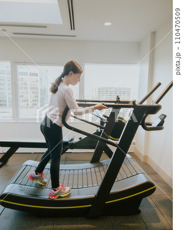 A dedicated young athlete giving her all, running on a treadmill in the gym. A dedicated young athlete giving her all, running on a treadmill in the gym. 110470509