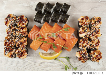 Set of various sushi rolls on a white wooden background. Japanese food. 110471004