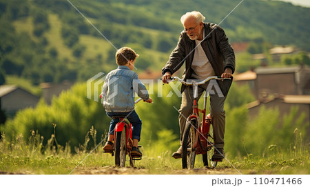 grandfather teaches grandson to ride a bike grandfather teaches grandson to ride a bike 110471466