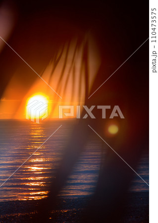 Warm sea, tropical sunset and carved palm leaves. Warm sea, tropical sunset and carved palm leaves. 110473575