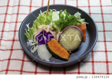 ドレッシングをかけたお皿に盛り付けた蒸し野菜のサラダ ドレッシングをかけたお皿に盛り付けた蒸し野菜のサラダ 110474120