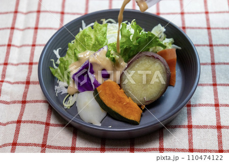 ドレッシングをかけたお皿に盛り付けた蒸し野菜のサラダ ドレッシングをかけたお皿に盛り付けた蒸し野菜のサラダ 110474122