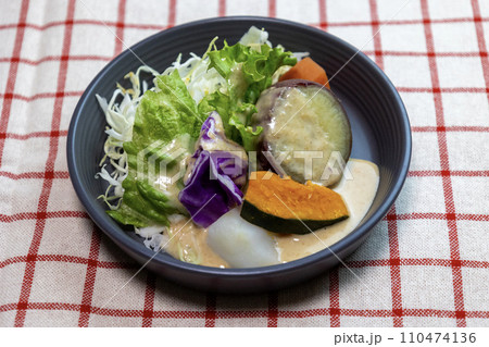 ドレッシングをかけたお皿に盛り付けた蒸し野菜のサラダ ドレッシングをかけたお皿に盛り付けた蒸し野菜のサラダ 110474136
