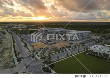 View from above of unfinished frame of apartment condos with wooden roof beams under construction. Development of residential housing in US suburbs. Real estate market in the USA 110474228