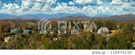 View from above of expensive residential houses high on hill top between yellow fall trees in suburban area in North Carolina. American dream homes as example of real estate development in US suburbs 110474230